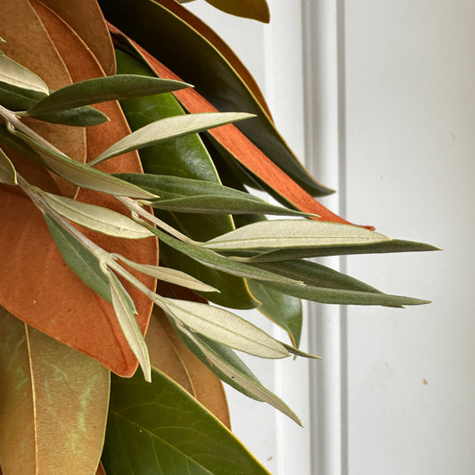 close up shot of olive in fresh handmade magnolia olive and pumpkin tree wreath for fall autumn and Thanksgiving decor