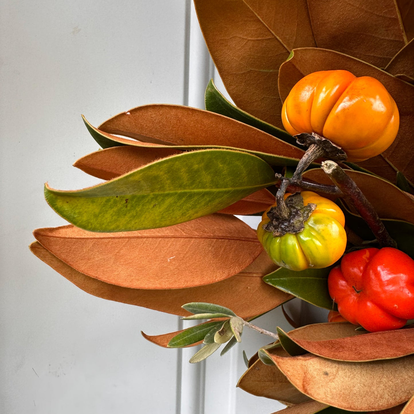 close up of magnolia leaves in fresh handmade magnolia olive and pumpkin tree wreath for fall autumn and Thanksgiving decor