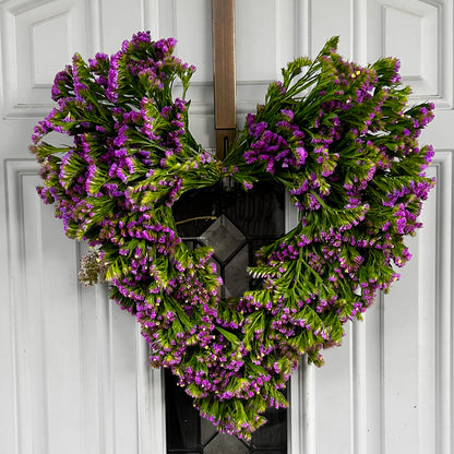 purple statice heart wreath hung against a white door